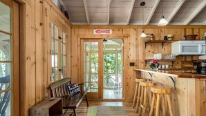 Un intérieur en bois comprenant un coin cuisine, un banc et un tabouret de bar.