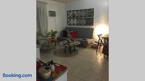 A living room with a sofa, a coffee table, and a dining table. - 1 Bedroom Apt near Coconut Grove (Miami)
