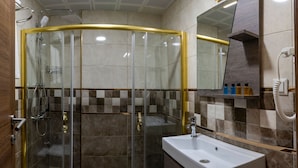A modern bathroom with a glass-enclosed shower, a white sink, and a mirror above it. - New Emin Hotel (Istanbul)