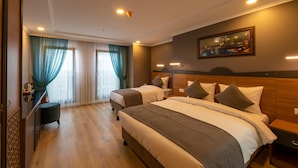 A hotel room with two beds, a desk, and a painting on the wall. - New Emin Hotel (Istanbul)