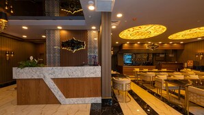 A hotel lobby with a marble reception desk, seating area, and decorative ceiling lights. - New Emin Hotel (Istanbul)