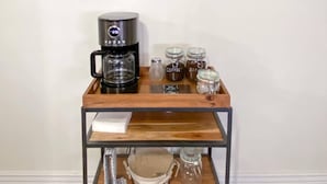 Un chariot à café équipé d’une machine à café, de pots de café et d’une pancarte sur laquelle on peut lire : « Les meilleures journées commencent toujours par un café. »