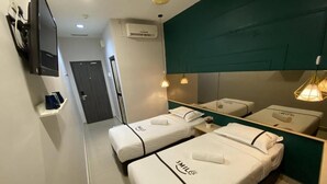 Hotelkamer met twee bedden, elk met een witte matras en bijpassende kussens, een flatscreen televisie aan de muur, een klein plankje met een blauw object, en een spiegel die het interieur van de kamer reflecteert.