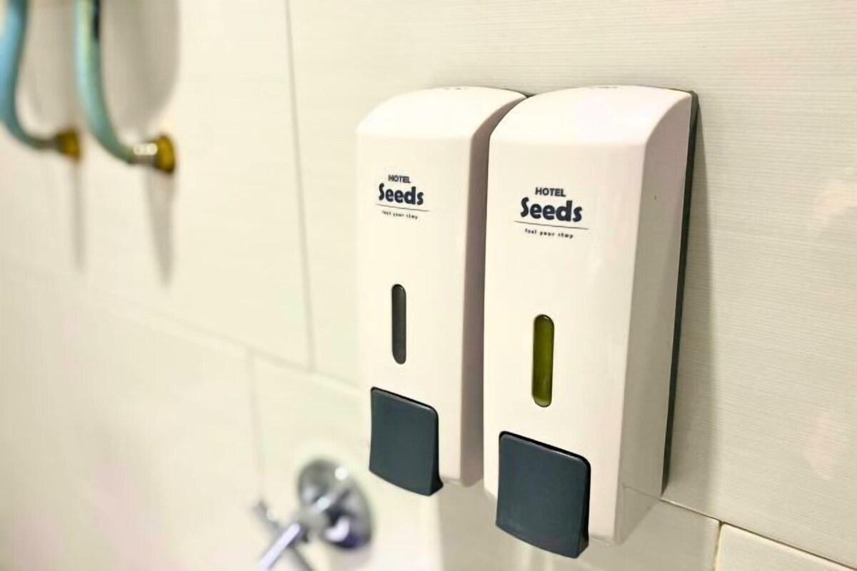 Ein an der Wand befestigter Handdesinfektionsmittelspender mit dem Aufdruck 'HOTEL Seeds'.