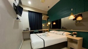 Een moderne hotelkamer met een bed, nachtkastjes, een bureau en een grote spiegel.