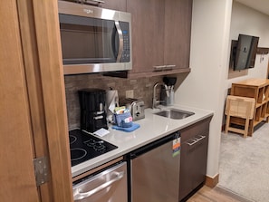 Cocina compacta equipada con microondas, cafetera, tostadora y lavavajillas.