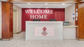 Ein Empfangstresen mit einem 'Welcome Home' Schild und dem Logo 'Best Western Plus'.