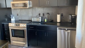 Eine moderne Küche mit Edelstahlgeräten, einer eingebauten Mikrowelle, einem Toaster und einer Kaffeemaschine.