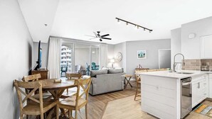 Une cuisine moderne avec un îlot central blanc, une table à manger en bois et des chaises.