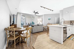 Una cocina moderna con una isla blanca, una mesa de comedor de madera y sillas.