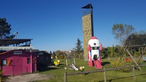 A playground with a slide, climbing wall, and a building labeled 'PISCINA'. - Landshause Bungalow T3 - 6D (Pataias)