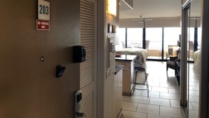 Habitación de hotel con kitchenette, comedor y balcón.