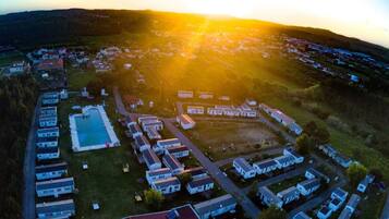 An aerial view of a residential area with multiple houses and a swimming pool.