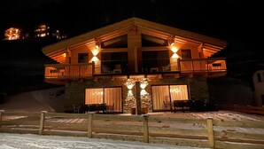Eine Lodge mit Holzfassade, Steinmauern und einem Balkon mit Geländer.