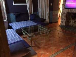 Relax in this charming room with two single beds, a brick wall, and a stone fireplace.