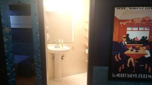 A bathroom with a sink, mirror, and tiled floor. - DuPont - Scandinavian Café & Garden Apartment (Washington)