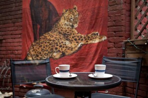 Enjoy casual dining in a charming outdoor setting with a beautiful leopard painting.