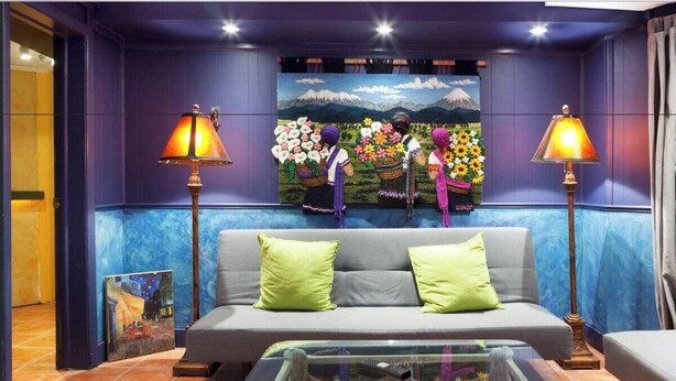 A room with a grey sofa, two green cushions, a glass coffee table, and two lamps. - DuPont - Scandinavian Café & Garden Apartment (Washington)