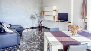 Un salon moderne comprenant un canapé, une table basse et un coin repas avec une table et des chaises.