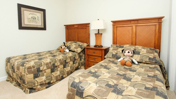 Two twin beds with matching headboards, a bedside table with a lamp, and a framed picture on the wall. - New Listing! Windsor Hills Resort, 3mi to Disney & 12mi to Universal - GRH438887 (Kissimmee)