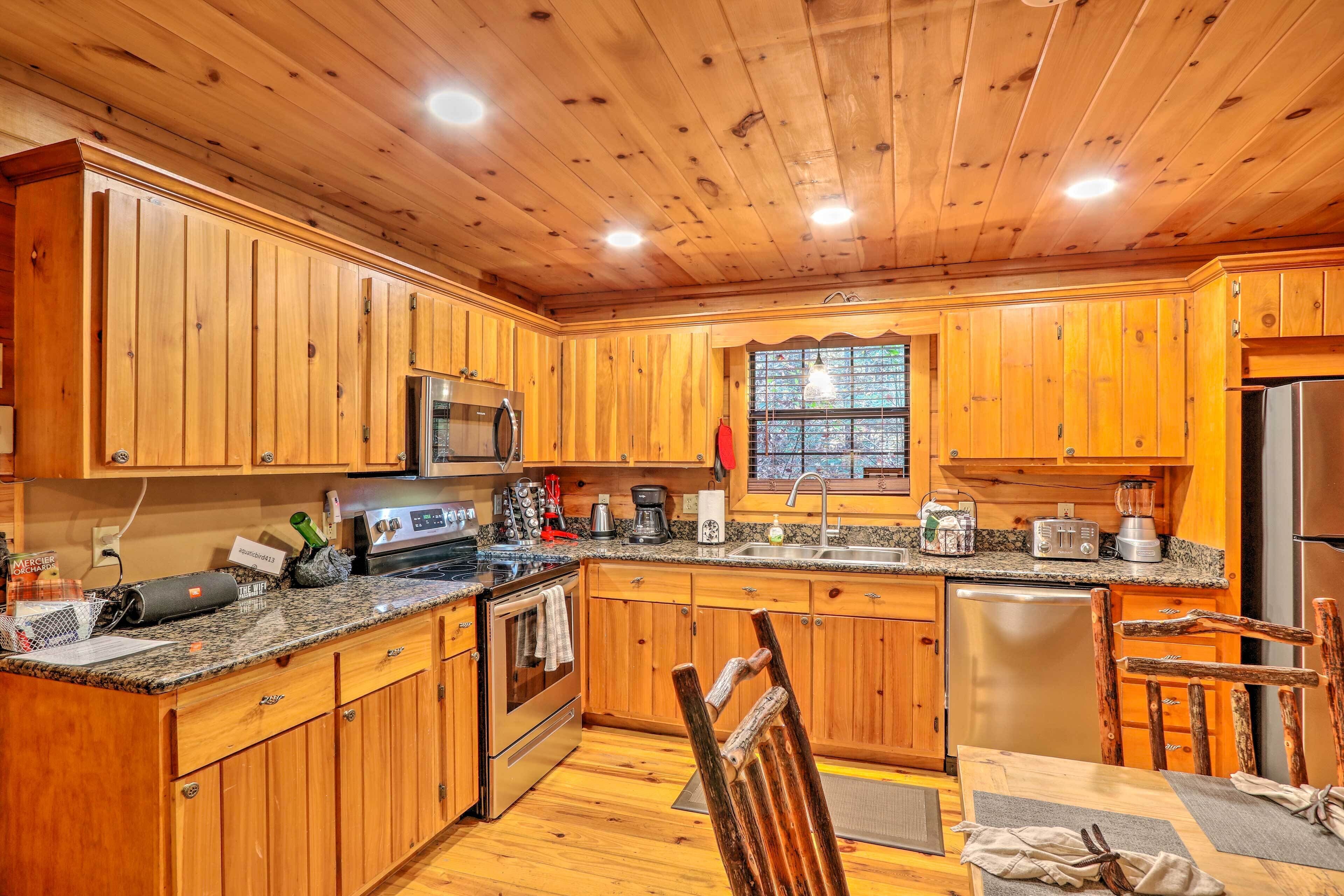 A kitchen with wooden cabinets, granite countertops, stainless steel appliances, and a dining area with a wooden table and chairs.