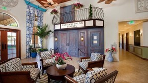 A lobby with a cinema named 'Paradise Palms Cinema', featuring a seating area with patterned chairs and a central table with a flower vase. - New Listing! Paradise Palms Resort, 6mi to Disney & 14mi to Universal - GRH438739 (Kissimmee)