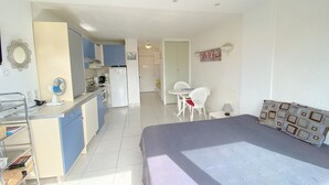 A compact hotel room with a kitchenette, a dining area, and a bed. - Cozy Studio with Pool Access, Port View, Parking Included - Agde (Cap d'Agde naturisme)
