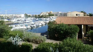 A marina with boats docked, surrounded by greenery and buildings in the background. - Cozy Studio with Pool Access, Port View, Parking Included - Agde (Cap d'Agde naturisme)