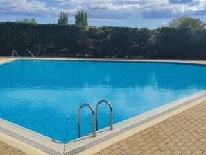A rectangular swimming pool with clear blue water, surrounded by a tiled deck. - Cozy Studio with Pool Access, Port View, Parking Included - Agde (Cap d'Agde naturisme)