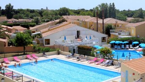 A rectangular swimming pool with multiple lanes, surrounded by lounge chairs and umbrellas. - Cozy Air-Conditioned Apartment with Pool Access, Terrace & Private Parking in Agde (Cap d'Agde naturisme)