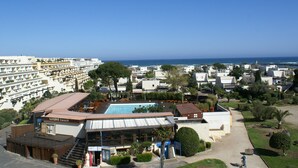 A resort with a swimming pool, beach view, and multiple buildings.