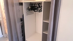 En rymlig klädkammare med öppna hyllor och plats för att hänga kläder.
