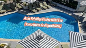 Piscina com espreguiçadeiras e guarda-sóis, e uma placa indicando o nome do hotel e seus serviços.