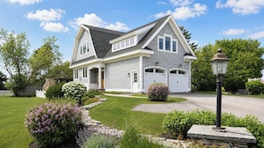 A two-story house with a grey exterior, a driveway, and a well-maintained lawn. - Happy Holidays with Sea Breeze (Scarborough)