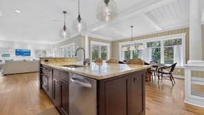 A spacious kitchen with a large island, pendant lighting, and a view of the outdoors. - Happy Holidays with Sea Breeze (Scarborough)