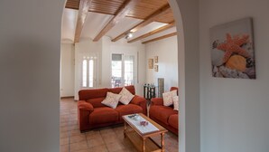 A living room with a wooden ceiling, two sofas with patterned cushions, a coffee table, and a painting of a starfish on the wall. - VILLA JAVI (Riumar)