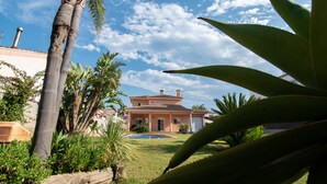 A house with a swimming pool, surrounded by palm trees and other greenery. - VILLA JAVI (Riumar)
