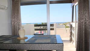 A balcony with a table, chairs, and a vase. - Air-conditioned apartment for 2 in Cap d'Agde (Cap d'Agde naturisme)