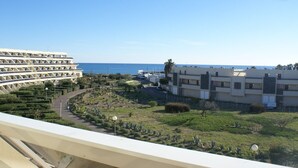 Blick auf einen Küstenort mit mehreren Gebäuden, einem angelegten Garten und freiem Blick auf das Meer.
