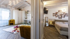 Un dormitorio moderno con cama, mesita de noche y televisor en la pared.