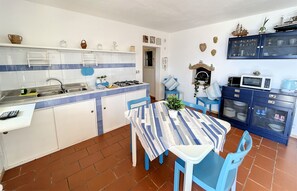 Een koelkast, kookgerei, borden en bestek