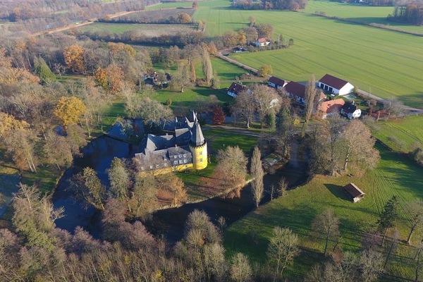 Schloss vom Wasser umgeben mit Park und Wirtschaftshof