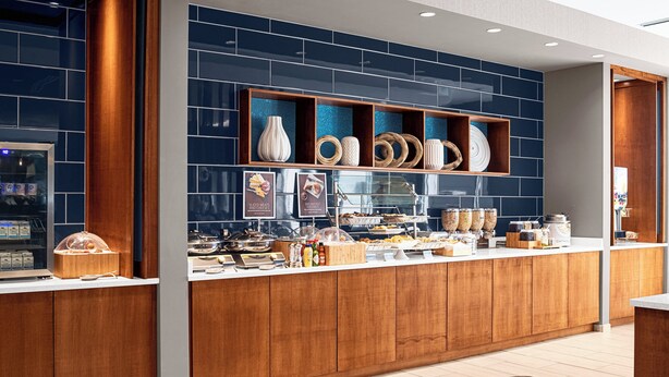 Een moderne ontbijtbar met diverse etenswaren en decoratieve vazen.
