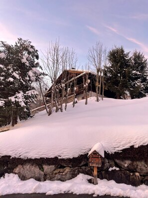 A wooden cabin with a sloped roof, surrounded by snow-covered trees and a stone wall. - Cozy chalet in the Aravis Mountains for 10 people, with a sauna (Saint-Jean-de-Sixt)