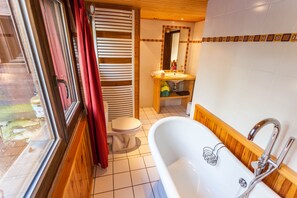 A bathroom with a bathtub, toilet, and sink. - Cozy chalet in the Aravis Mountains for 10 people, with a sauna (Saint-Jean-de-Sixt)