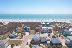 Zona residencial costera con casas, una playa y cielo despejado.