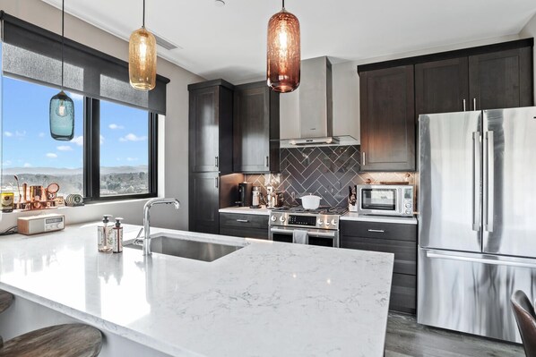 Enjoy cooking in this well-equipped kitchen with a large island, stainless steel appliances, and an oven.