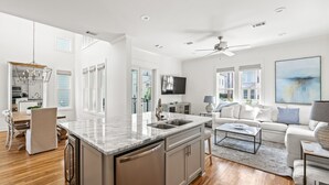 Un salón amplio con una isla grande, un conjunto de sofás y una mesa de comedor.