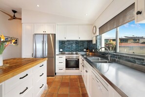 Enjoy cooking in this well-equipped kitchen with a refrigerator, oven, and double sink.