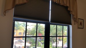 Janela com vista para um jardim e área de estar ao ar livre.